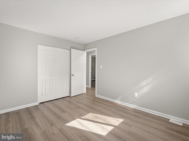 unfurnished bedroom featuring a closet and light wood-type flooring