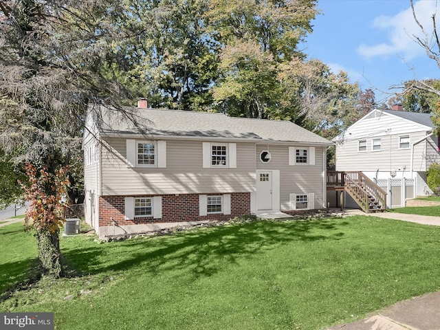 view of front of home with cooling unit and a front lawn