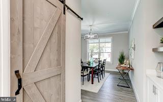 interior space with crown molding, a barn door, and dark hardwood / wood-style flooring