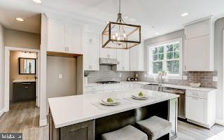 kitchen with a center island, pendant lighting, white cabinets, light hardwood / wood-style flooring, and a chandelier