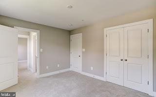 unfurnished bedroom featuring light carpet