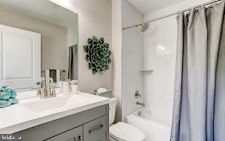 full bathroom with vanity, shower / tub combo with curtain, and toilet