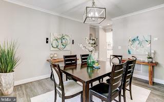 dining room featuring crown molding, wood-type flooring, and an inviting chandelier