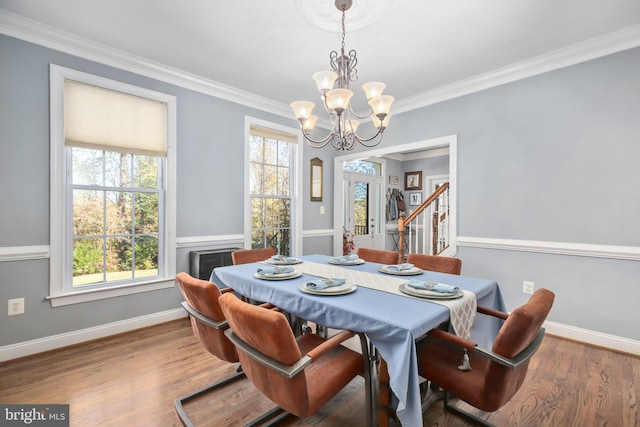 dining area featuring crown molding, hardwood / wood-style floors, a chandelier, and plenty of natural light