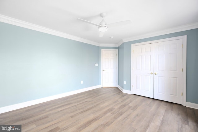 unfurnished bedroom featuring ornamental molding, a closet, light wood-type flooring, and ceiling fan