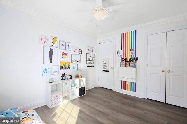 playroom with crown molding, dark hardwood / wood-style floors, and ceiling fan