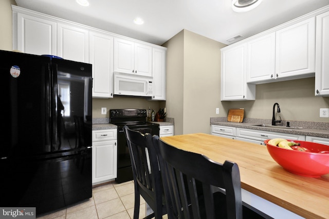 kitchen featuring sink, black appliances, and white cabinets