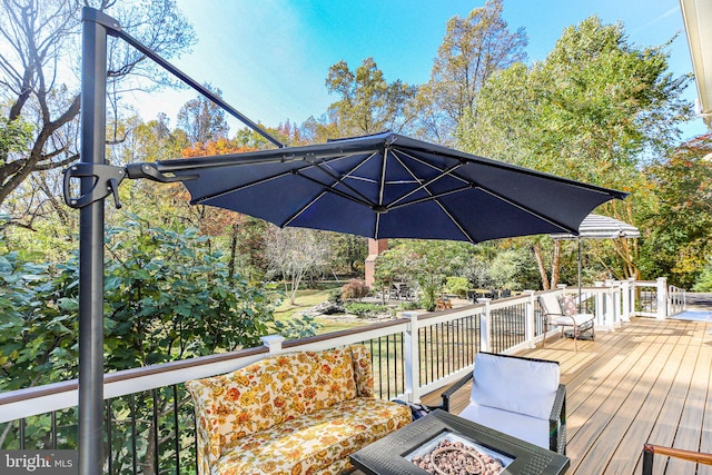 wooden terrace featuring an outdoor fire pit