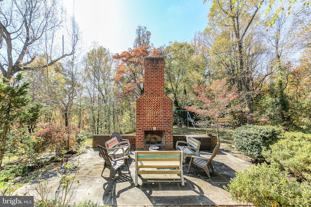 view of patio featuring an outdoor brick fireplace