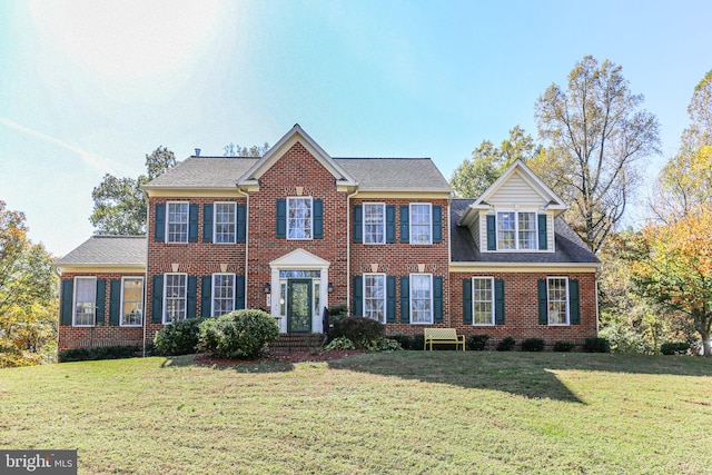 colonial inspired home featuring a front lawn