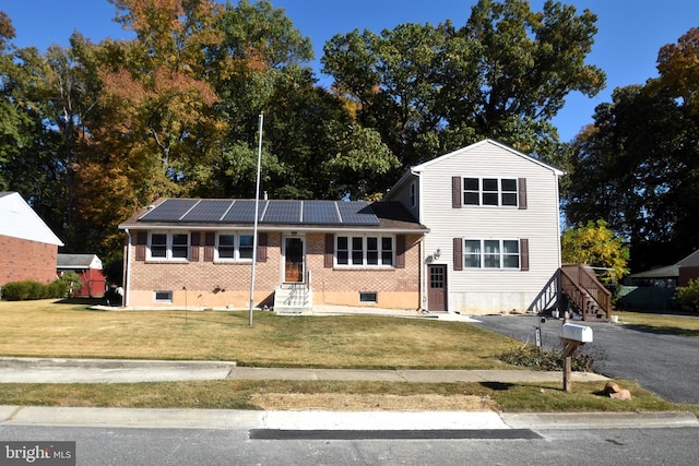 view of front of house with solar panels and a front lawn