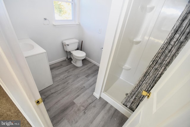 bathroom featuring vanity, toilet, curtained shower, and hardwood / wood-style floors