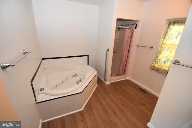 bathroom featuring wood-type flooring and separate shower and tub