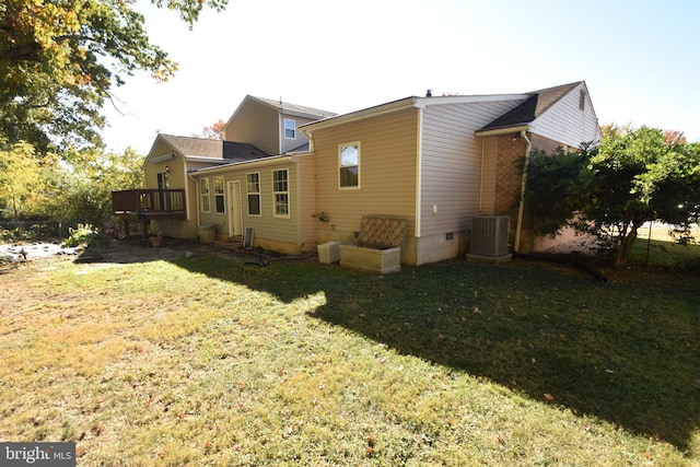 back of property featuring a deck, a yard, and central AC unit