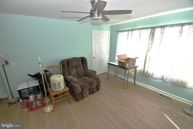 living area with hardwood / wood-style flooring and ceiling fan