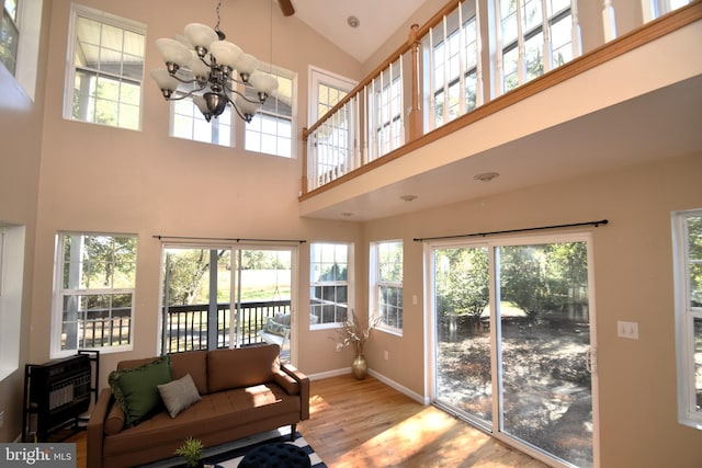 sunroom / solarium with a healthy amount of sunlight, lofted ceiling, and an inviting chandelier