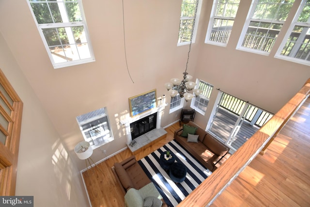 living room with a high ceiling, a notable chandelier, and hardwood / wood-style flooring