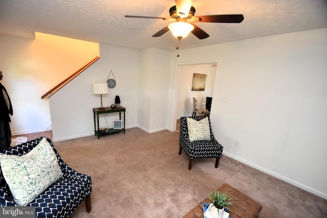 living area with carpet floors, a textured ceiling, and ceiling fan