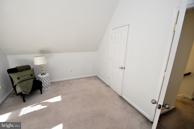 living area with lofted ceiling and light colored carpet