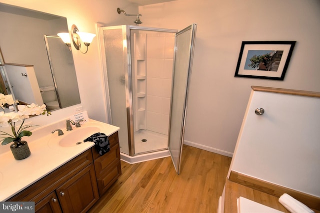 bathroom with a shower with door, toilet, wood-type flooring, and vanity