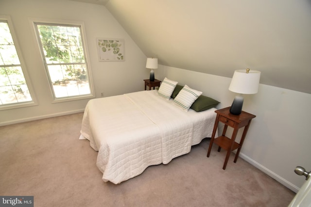 bedroom with light carpet and lofted ceiling