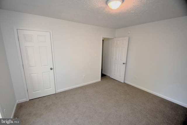 carpeted spare room featuring a textured ceiling