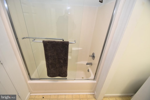 bathroom featuring combined bath / shower with glass door