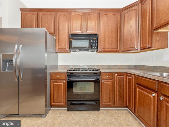 kitchen featuring black appliances and light tile patterned floors