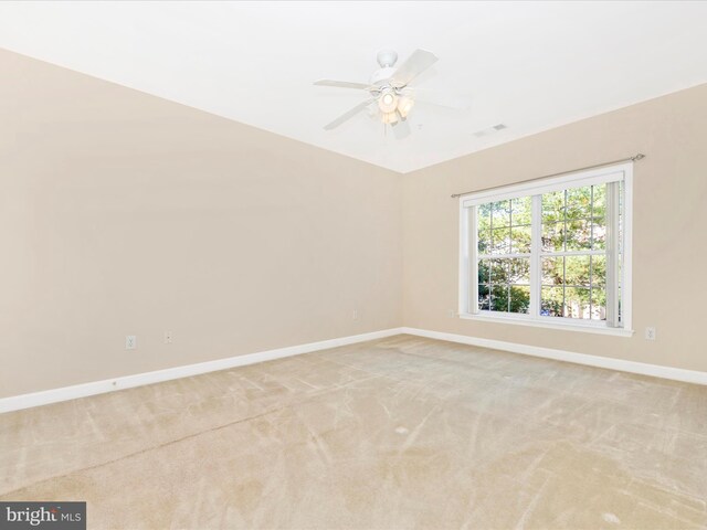 spare room featuring light colored carpet and ceiling fan