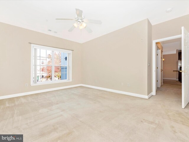 carpeted spare room with ceiling fan