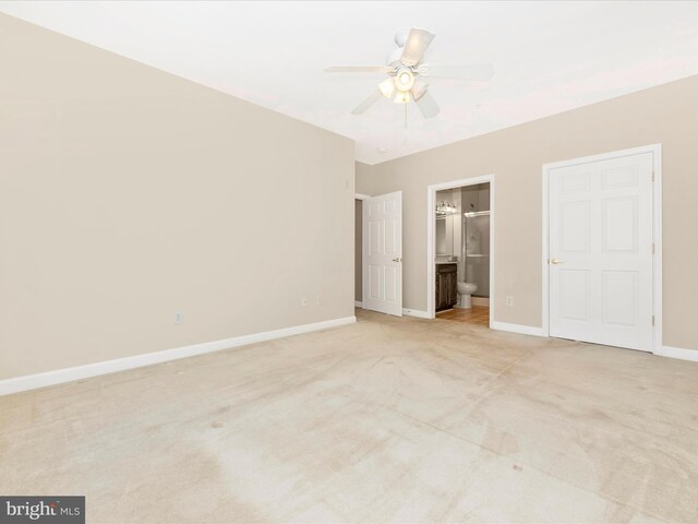 unfurnished bedroom with light colored carpet, ceiling fan, and connected bathroom