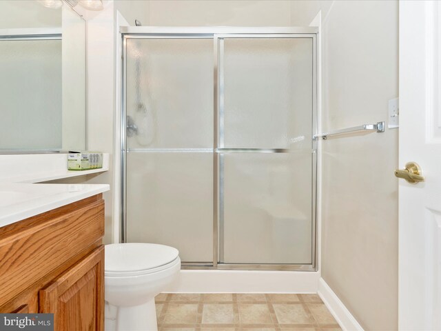 bathroom featuring an enclosed shower, vanity, and toilet