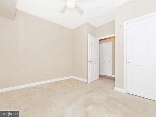 unfurnished bedroom with light colored carpet and ceiling fan