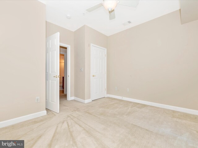 unfurnished bedroom with light carpet and ceiling fan