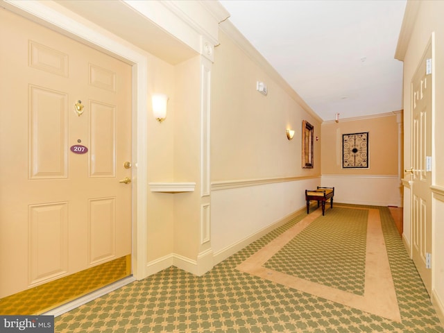 hall featuring ornamental molding and carpet flooring