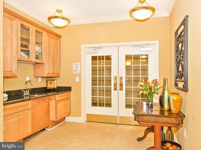 kitchen with dark stone counters, sink, crown molding, and light tile patterned floors