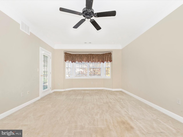 carpeted empty room featuring ceiling fan and crown molding