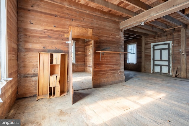 spare room with wood finished floors, beam ceiling, wood walls, and wooden ceiling