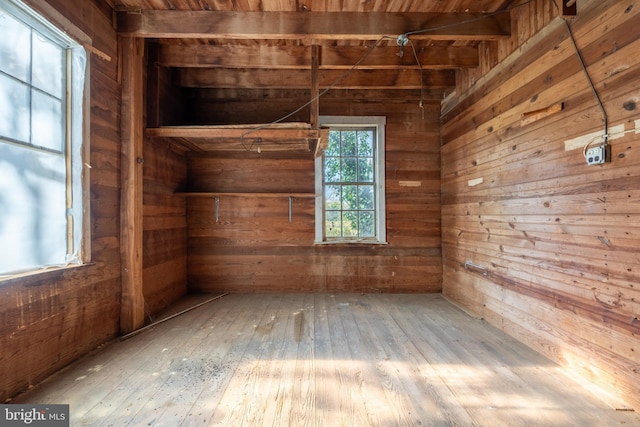 unfurnished room featuring hardwood / wood-style floors and wooden walls