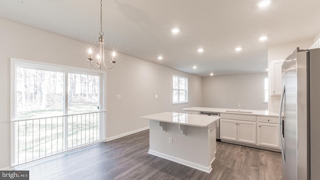 kitchen with dark wood-type flooring, white cabinets, hanging light fixtures, and stainless steel fridge with ice dispenser