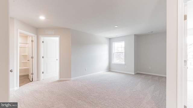 carpeted spare room with baseboards, visible vents, and recessed lighting