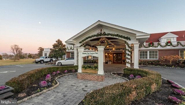property at dusk with curved driveway