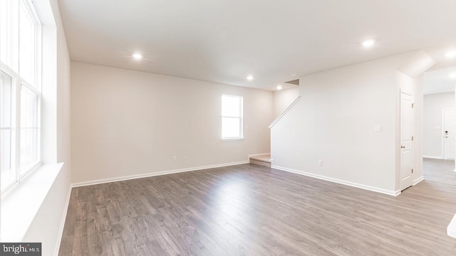 interior space featuring baseboards, stairs, wood finished floors, and recessed lighting