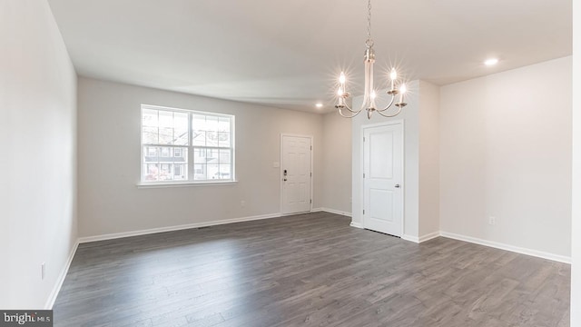 empty room with baseboards, recessed lighting, a chandelier, and dark wood finished floors