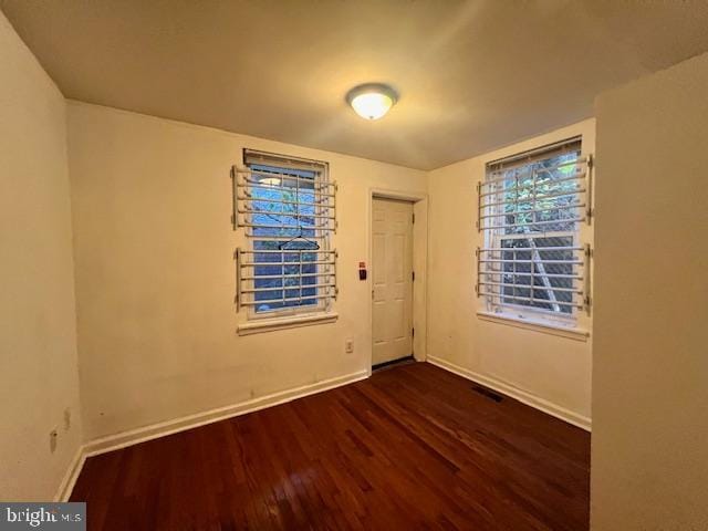 unfurnished room with dark hardwood / wood-style floors