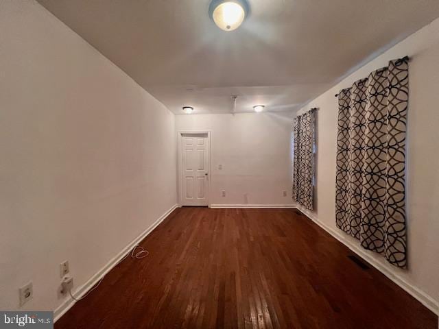 unfurnished room with dark hardwood / wood-style flooring