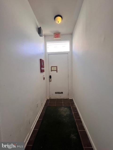 doorway to outside with dark tile patterned floors