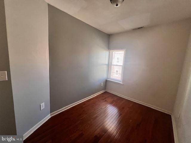 spare room featuring dark wood-type flooring