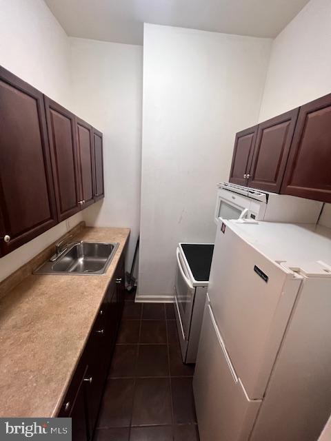 kitchen with range with electric cooktop, sink, dark tile patterned floors, and white refrigerator