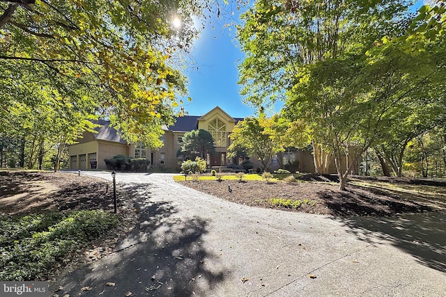 view of property hidden behind natural elements with a garage